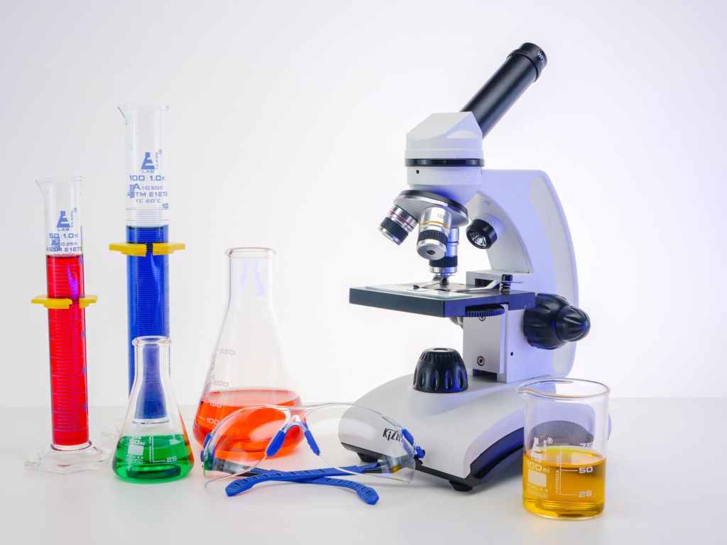 a microscope and colorful liquids in laboratory glasswares
